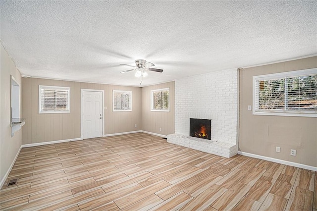 unfurnished living room featuring ceiling fan, a textured ceiling, and a fireplace