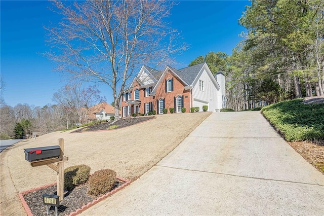 view of front of house with concrete driveway and brick siding