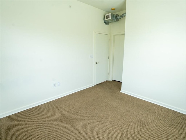 unfurnished room with dark colored carpet and baseboards