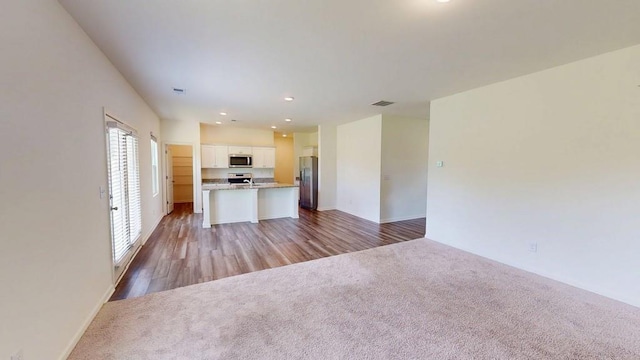 131 Andria Way, Cartersville, GA 30120 - kitchen with stainless steel appliances, open floor plan, white cabinets, carpet floors, and a center island with sink