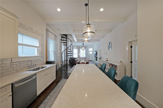 kitchen featuring stainless steel dishwasher, open floor plan, dark wood-type flooring, a sink, and coffered ceiling
