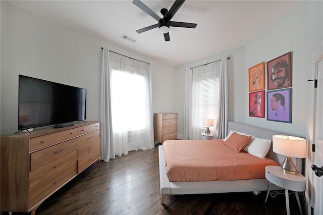 bedroom featuring ceiling fan, visible vents, and wood finished floors