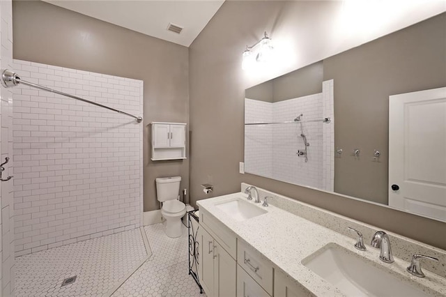 full bathroom with visible vents, a sink, toilet, and tiled shower