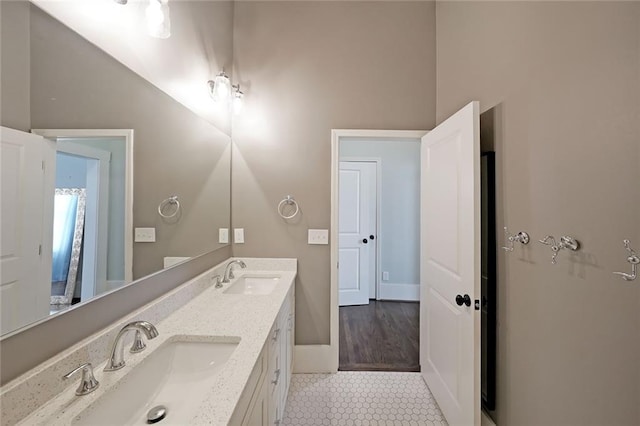 bathroom with tile patterned flooring, a sink, and double vanity