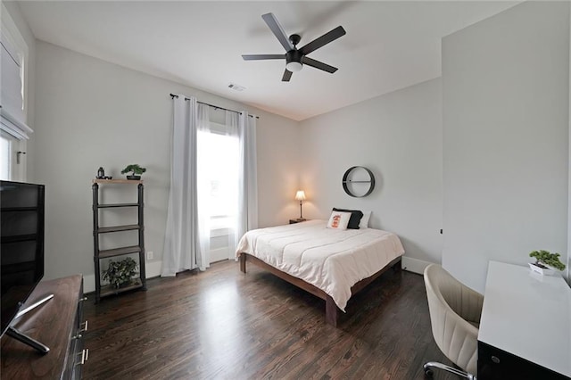 bedroom featuring baseboards, a ceiling fan, wood finished floors, and visible vents