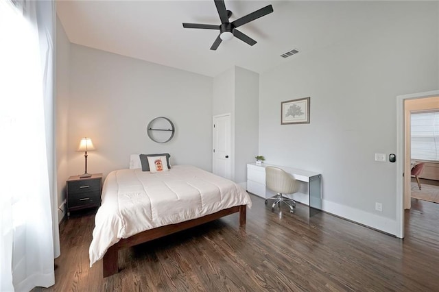 bedroom featuring baseboards, a ceiling fan, wood finished floors, and visible vents