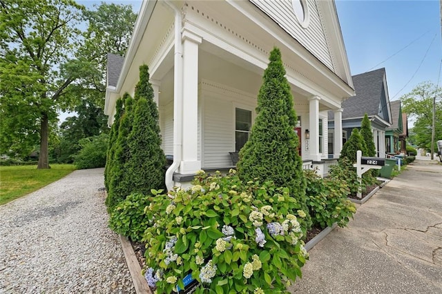 view of side of property with roof with shingles and driveway