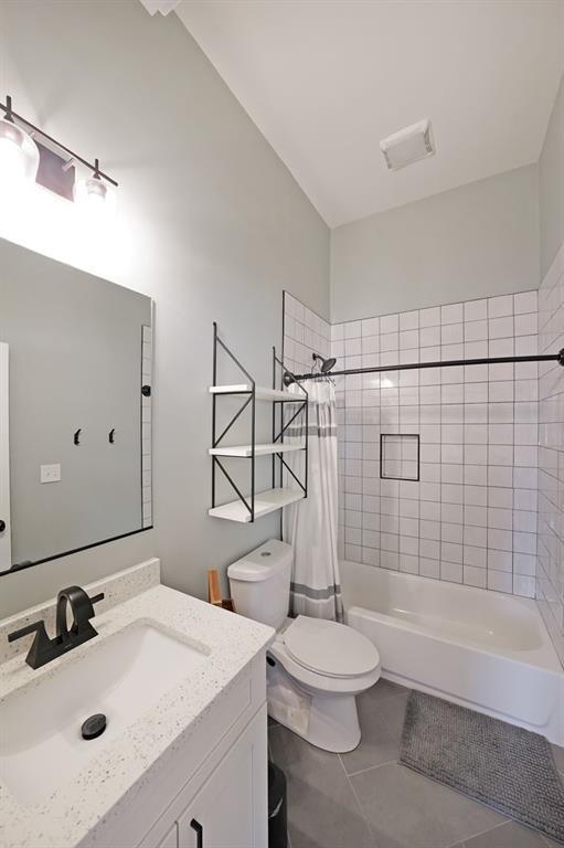 full bathroom with visible vents, tile patterned floors, vanity, toilet, and shower / bathtub combination with curtain