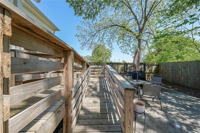 wooden terrace with fence and a patio area