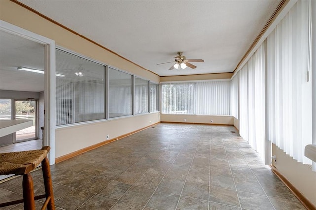 unfurnished sunroom featuring ceiling fan