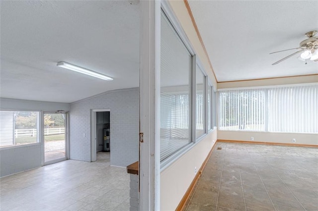 unfurnished sunroom with ceiling fan and vaulted ceiling