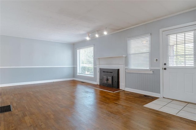 unfurnished living room with hardwood / wood-style flooring and ornamental molding