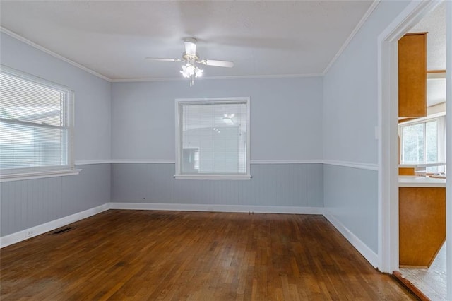 empty room featuring crown molding, ceiling fan, and dark wood-type flooring