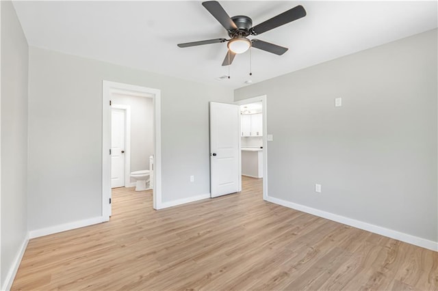 unfurnished bedroom with a walk in closet, ensuite bathroom, light hardwood / wood-style flooring, and ceiling fan