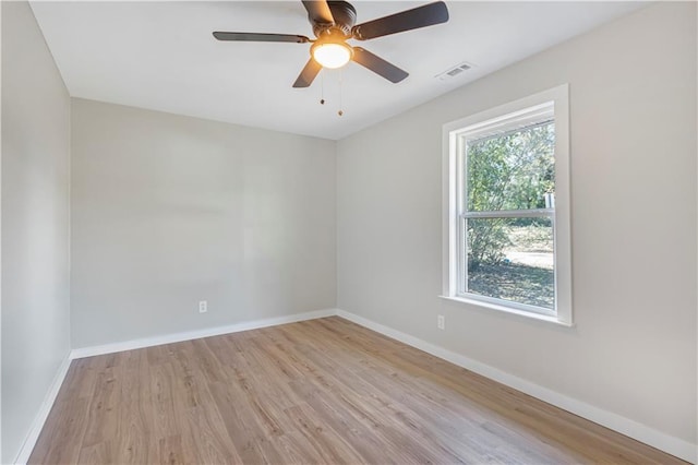 empty room with ceiling fan, plenty of natural light, and light wood-type flooring