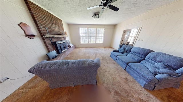 living room with a textured ceiling, carpet floors, and ceiling fan