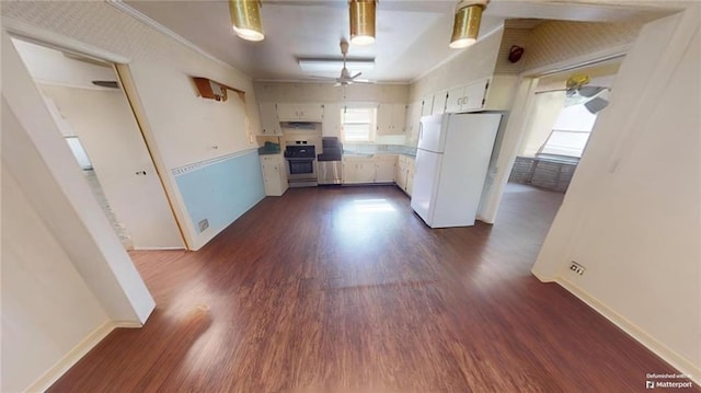 kitchen with range, dark hardwood / wood-style flooring, white fridge, and white cabinetry