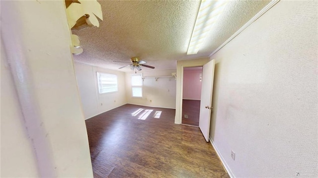 unfurnished room featuring ceiling fan, dark hardwood / wood-style flooring, and a textured ceiling