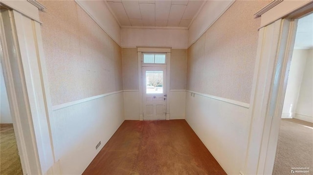 doorway to outside featuring carpet floors and ornamental molding