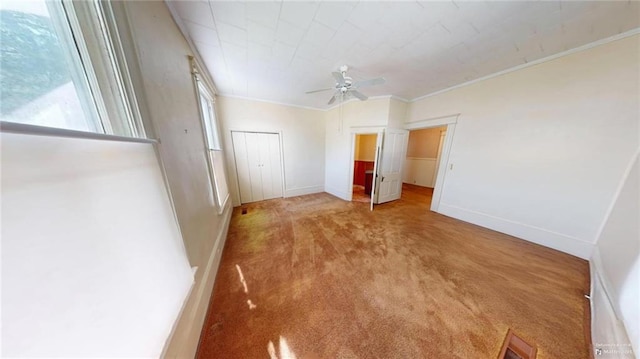 unfurnished bedroom with light colored carpet, ceiling fan, and crown molding