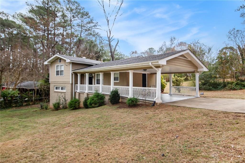 view of front of property with a carport, a porch, and a front lawn