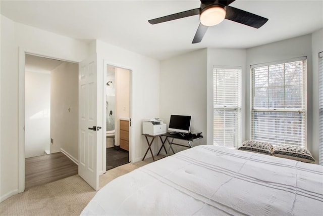 bedroom with ceiling fan, light wood-type flooring, and ensuite bath