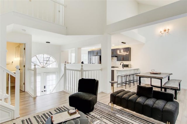 living room featuring a towering ceiling and light hardwood / wood-style floors