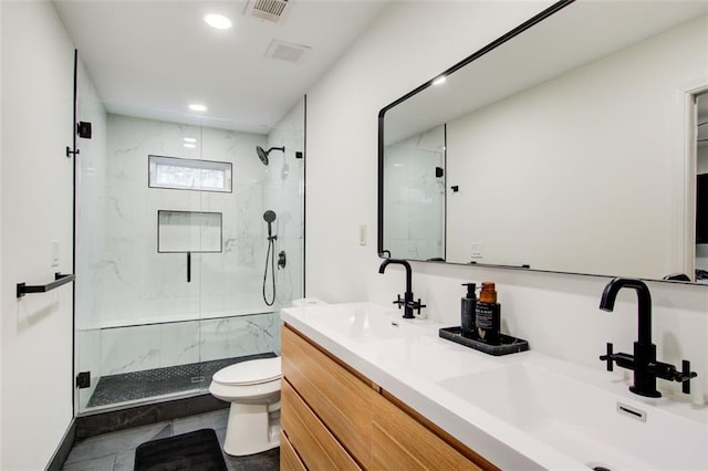 bathroom featuring tile patterned flooring, vanity, a shower with shower door, and toilet