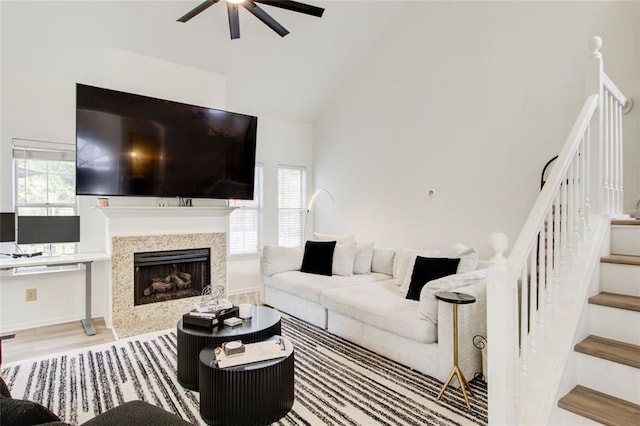 living room with ceiling fan, light hardwood / wood-style flooring, and high vaulted ceiling