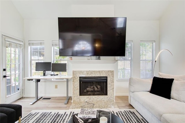 living room with light hardwood / wood-style floors and a high end fireplace