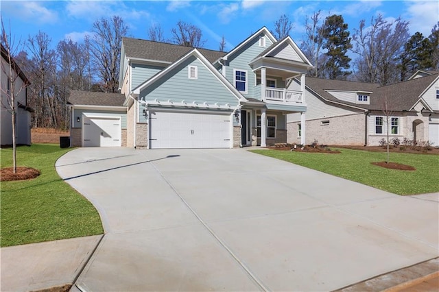 view of front of property with a balcony, a front lawn, and a garage