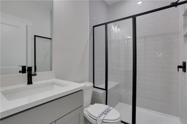 bathroom featuring toilet, walk in shower, and vanity