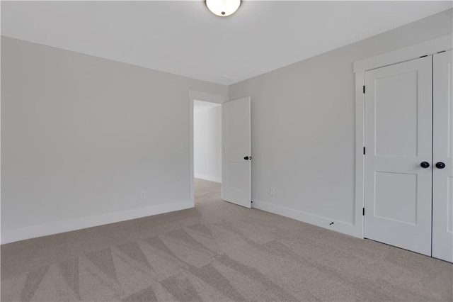 unfurnished bedroom with a closet and light carpet