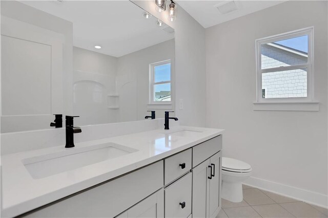 bathroom with vanity, tile patterned flooring, plenty of natural light, and toilet