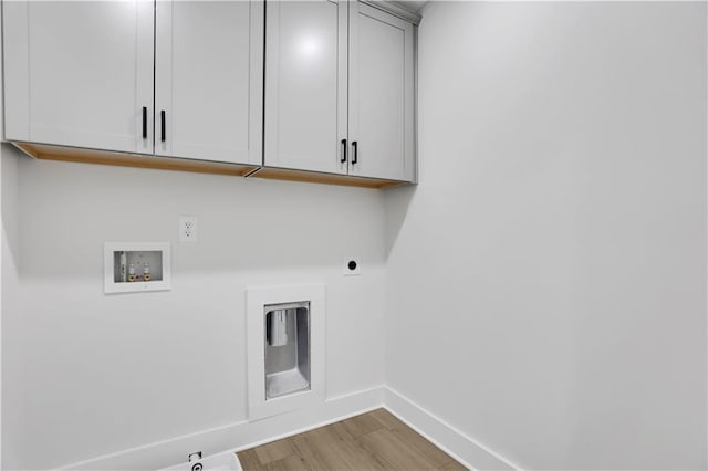 washroom featuring cabinets, light hardwood / wood-style floors, hookup for a washing machine, hookup for a gas dryer, and hookup for an electric dryer