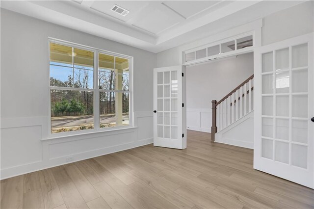 unfurnished room featuring light hardwood / wood-style floors, french doors, and coffered ceiling