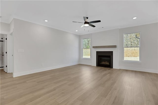 unfurnished living room with a fireplace, ceiling fan, and light hardwood / wood-style flooring