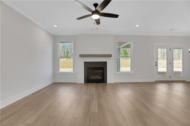 unfurnished living room with a healthy amount of sunlight, ceiling fan, light hardwood / wood-style flooring, and a fireplace