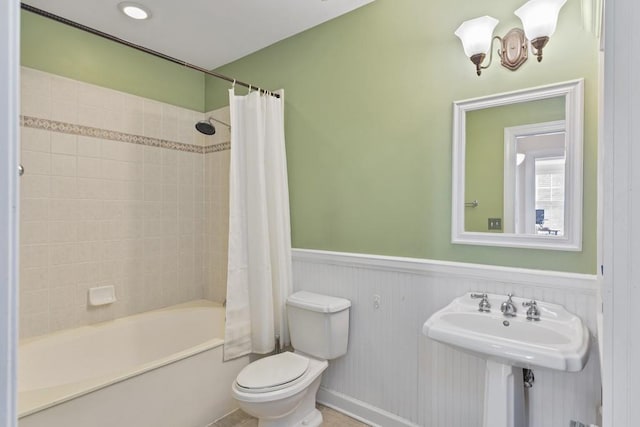 bathroom featuring shower / bath combination with curtain and toilet