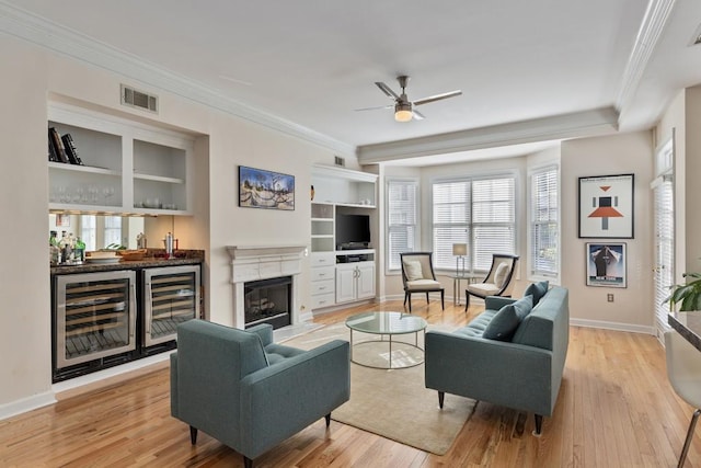 living room with bar area, light hardwood / wood-style flooring, and beverage cooler