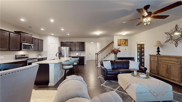 living area featuring ceiling fan, stairway, dark wood finished floors, and recessed lighting