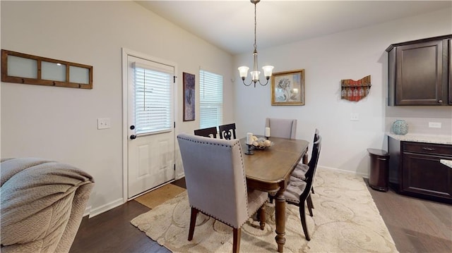 dining room featuring a notable chandelier, wood finished floors, and baseboards