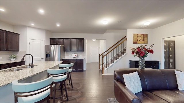 kitchen featuring dark brown cabinetry, dark wood finished floors, stainless steel refrigerator with ice dispenser, and a sink