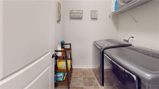 clothes washing area featuring laundry area, baseboards, and washer and clothes dryer