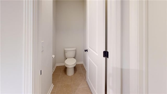 bathroom featuring tile patterned flooring, toilet, and baseboards