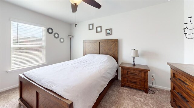 bedroom featuring light carpet and baseboards