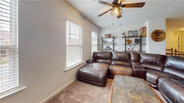 carpeted living room featuring a ceiling fan and baseboards