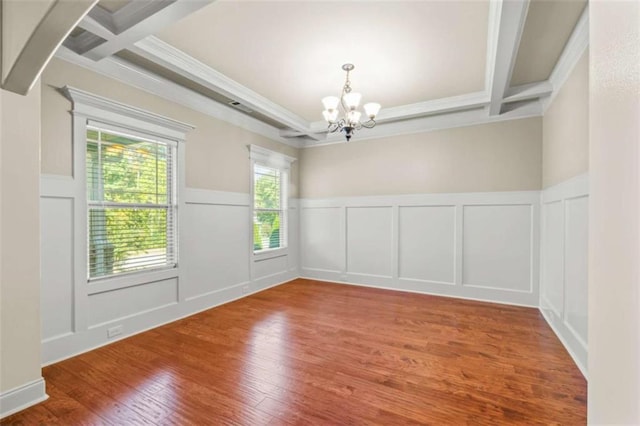 empty room with beam ceiling, coffered ceiling, and hardwood / wood-style flooring