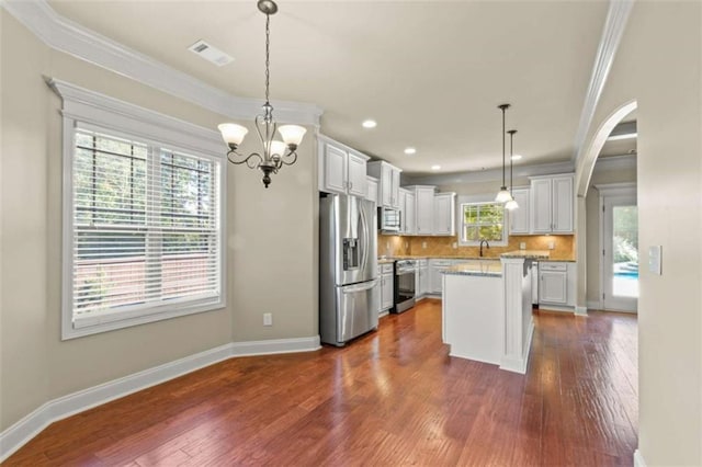 kitchen featuring a kitchen island, visible vents, white cabinetry, hanging light fixtures, and appliances with stainless steel finishes