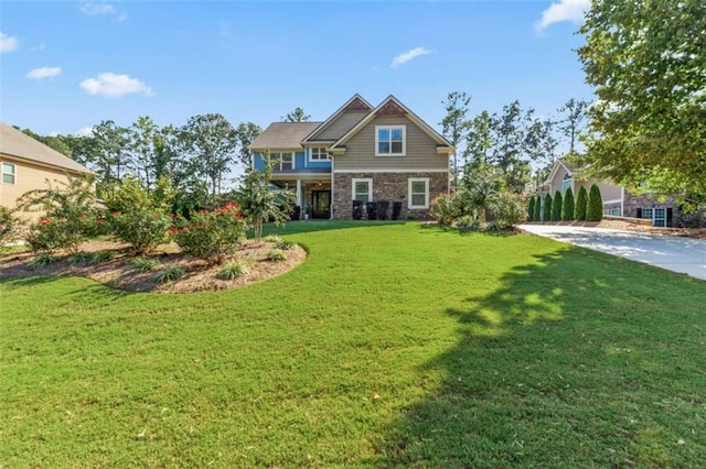 craftsman-style house with a front yard and stone siding